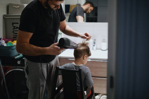 istock Father cutting son's hair at home during isolation 1219013973