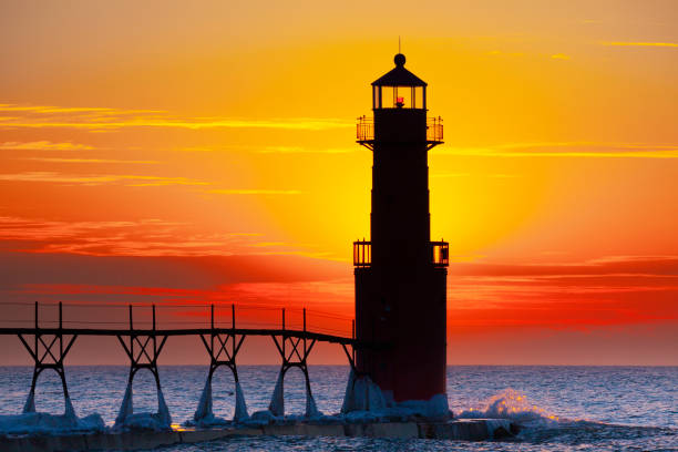 istock Iconic Lighthouse in icy cold harbor, silhouetted against dawn sky. 1219014014