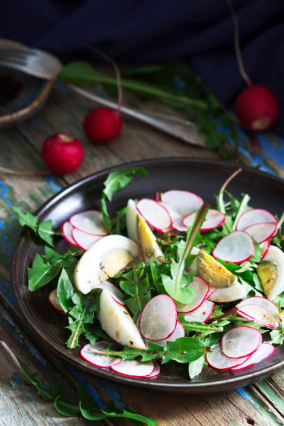 istock Salad with dandelion, egg and radish on a wooden background. Rustic style. 1219015693
