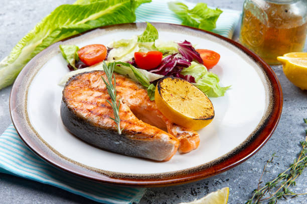istock salmon steak and salad with tomatoes 1219015699