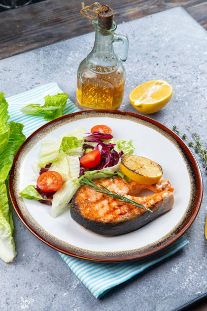 istock salmon steak and salad with tomatoes 1219015729