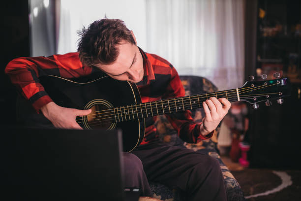 istock A man playing guitar next to a laptop 1219016898