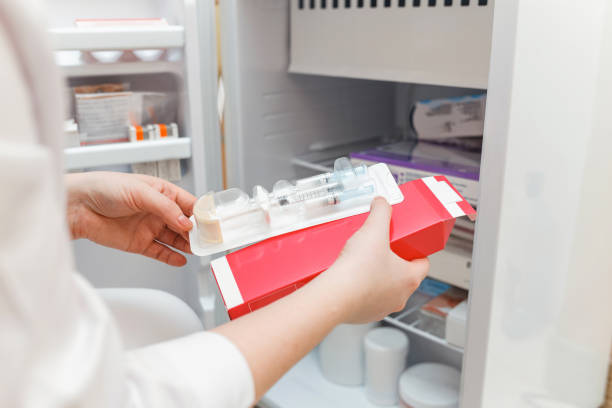 läkaren tar ut medicin från kylskåpet med en engångsspruta - vaccinkyl bildbanksfoton och bilder