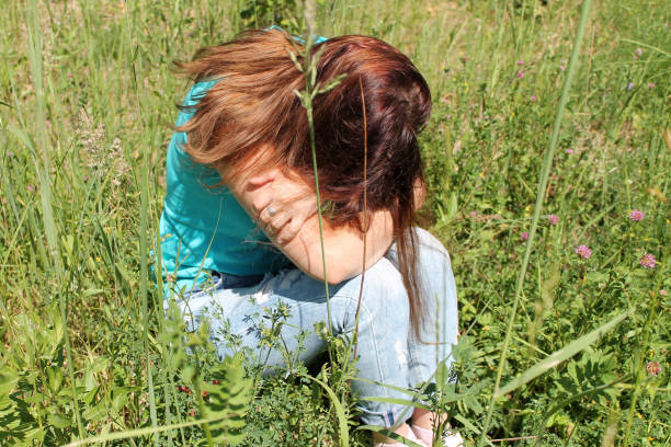 istock Sad lonely girl is sitting on the grass. 1219020351