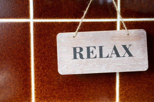 A Wooden Relax Sign on a brown tiled Wall, retro design background texture retro