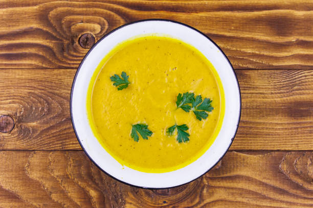 istock Pumpkin soup on a wooden table. Top view 1219023959