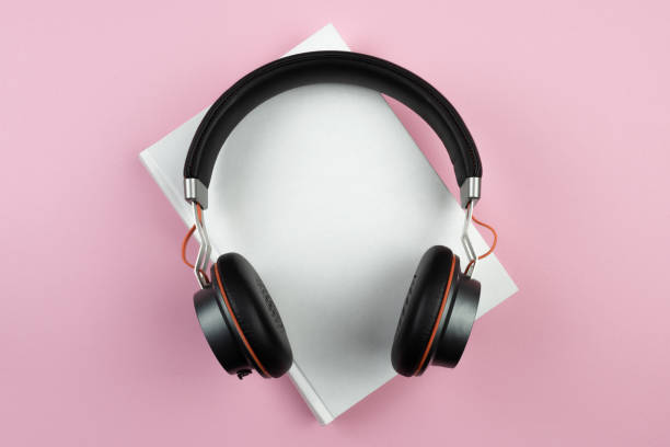 conceito audiobook, visão superior de fones de ouvido estéreo em livro de capa dura - hardcover book audio - fotografias e filmes do acervo