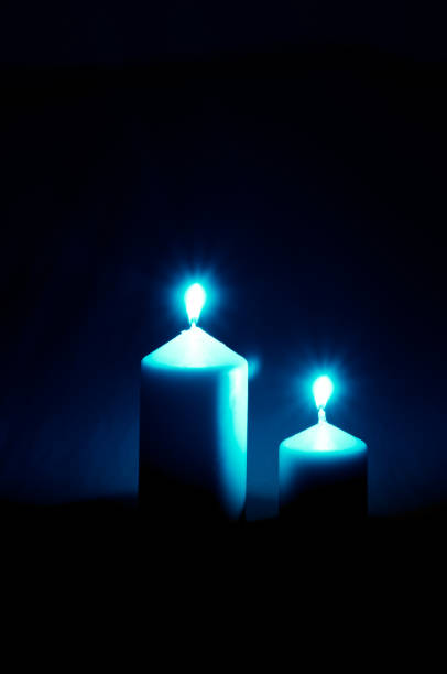 two illuminated burning wax candles with black copy space background