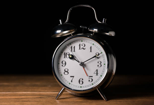 istock A old vintage alarm clock with bell in a brown wood table 1219025500