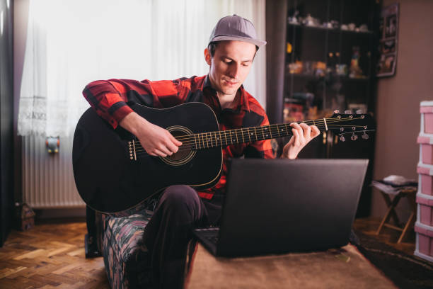 istock A man playing guitar next to a laptop 1219025525