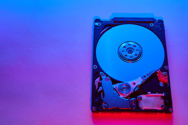 istock Disassembled hard drive from the computer, hdd with neon light. Opened hard drive Part of computer or laptop 1219026849