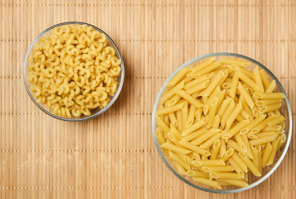 istock two bowls of dried pasta on a cane tablecloth 1219029831