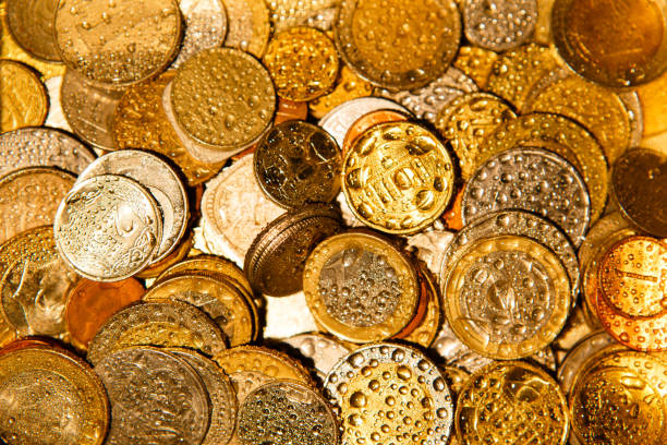istock Coins of different countries in Golden light and water splashes. 1219029892