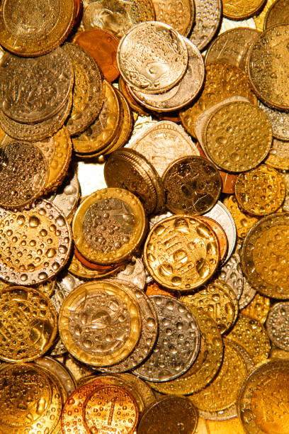 istock Coins of different countries in Golden light and water splashes. 1219029897
