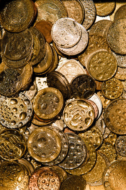 istock Coins of different countries in Golden light and water splashes. 1219029898