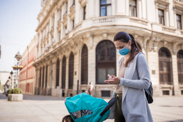 istock Mother disinfect her hands on the street 1219032020