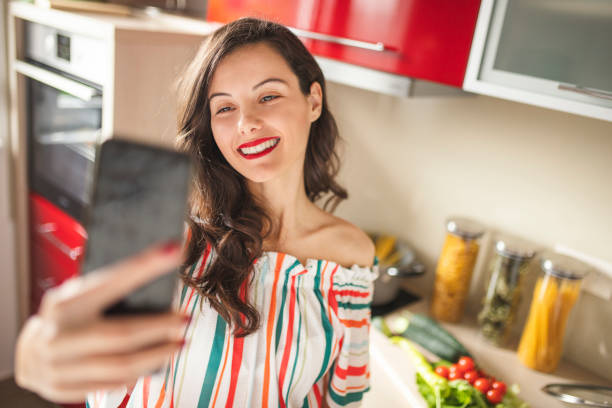 istock Beautiful woman cooking and using phone 1219032540