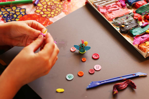 istock Children at the applique lesson cutting and pasting figures, patterns or whole pictures from pieces of paper. 1219035316