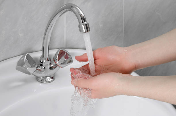 istock Human hands in bathroom are washed under tap water 1219035728