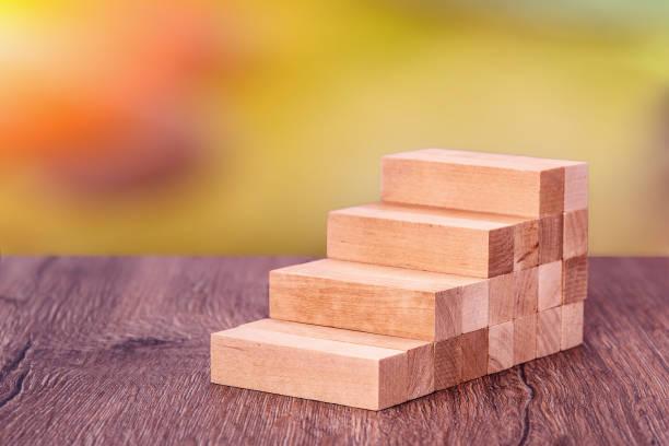 istock Man builds a wooden ladder. Concept: stable development 1219036315