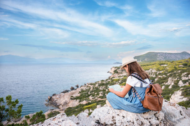 istock Hipster young girl with bright backpack enjoying panoramic mountain sea, using map and looking distance. 1219036363