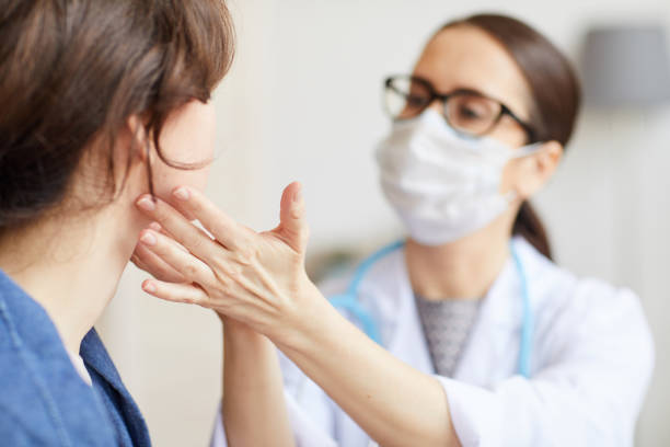 Doctor examining the patient Young woman sitting while the nurse examining her throat during visit at hospital human mouth stock pictures, royalty-free photos & images