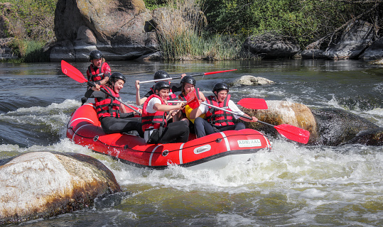 Pacuare River,  Costa Rica - March 14 2019: Rafting team , summer extreme water sport.  Group of people in a rafting boat, beautiful adrenaline ride down the river.