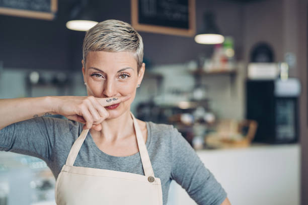 Funny mustaches Smiling barista showing a mustache tattoo on her finger women movember mustache facial hair stock pictures, royalty-free photos & images