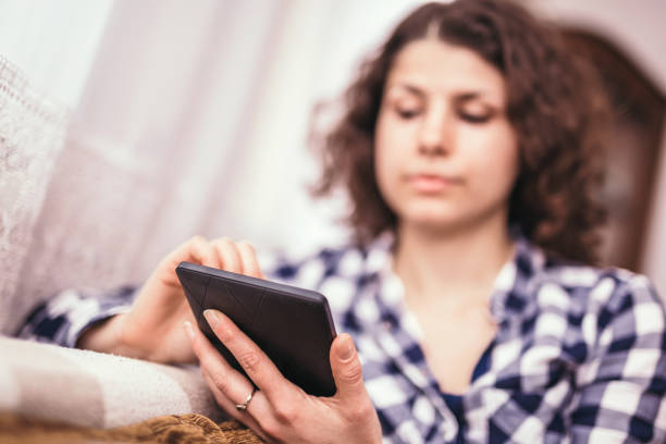 istock Woman relaxing indoors on tablet during lockdown 1219038134