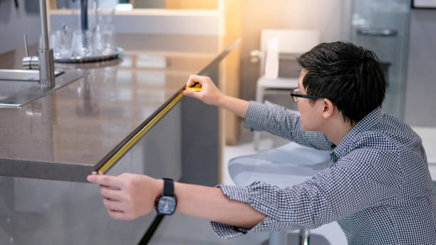 asiatischer mann mit maßband auf küchentheke - domestic kitchen kitchen sink contemporary counter top stock-fotos und bilder