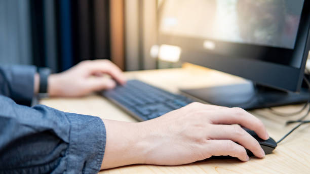 holding computer mouse while using computer - computer keyboard human hand computer internet imagens e fotografias de stock