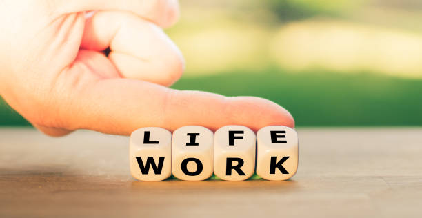 istock Live vs. work. Hand turns dice and changes the word 