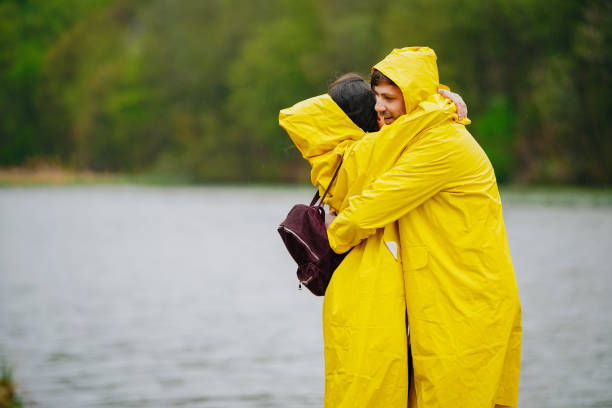 istock Happy couple in raincoats standing on the pier 1219040959