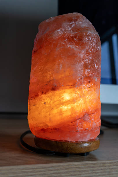 istock An orange pink glowing Himalayan salt lamp sits on a computer desk. Calming concept at work 1219041513