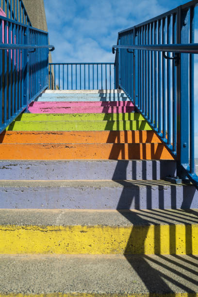 istock Concrete steps painted bright rainbow colours with a blue railing and a strong shadow pattern 1219043926