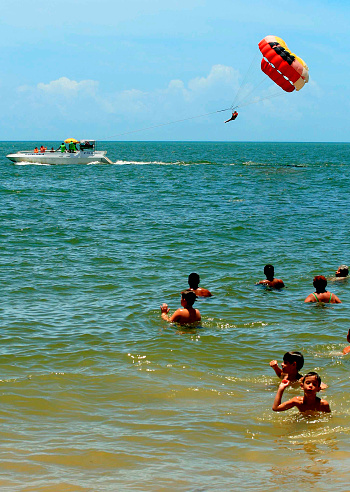 porto seguro, bahia / brazil - january14 2009: boat pulls paraseil on the beach in the city of Porto Seguro.\