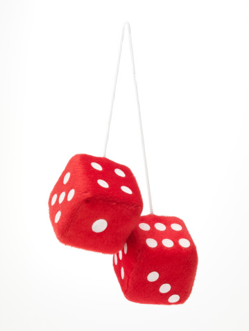 Red fuzzy dice hanging on white background