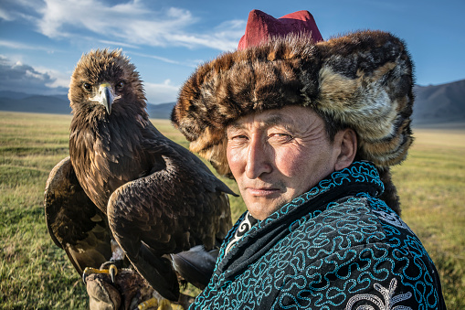 Bayan-Olgii, Mongolia- July 31 2017: Portrait of a traditional Mongolian eagle hunter and his animal.