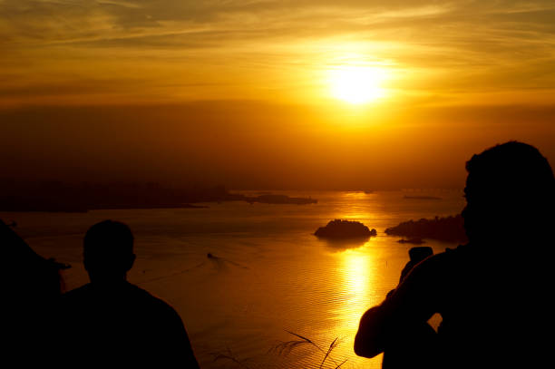 ludzie odpoczywający na zachodzie słońca w miastach niteroi i rio de janeiro w brazylii. widok na miejsca turystyczne w miastach, takie jak zatoka guanabara, kolejka linowa sugarloaf, pomnik chrystusa odkupiciela - brazil silhouette sunset guanabara bay zdjęcia i obrazy z banku zdjęć