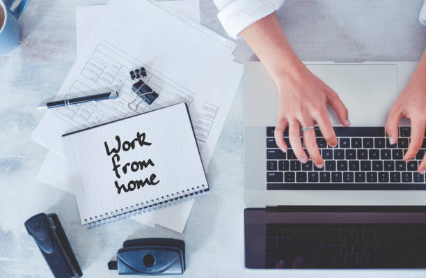 istock Top view of woman using laptop while sitting at the table with laptop, mobile phone, note pad, coffee cup. 1219057519