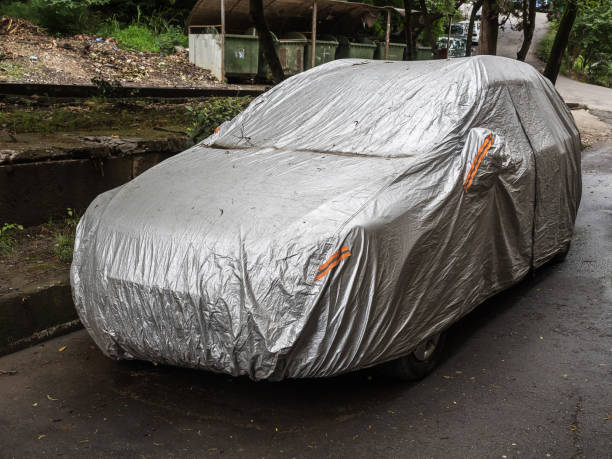 istock Parked car with protective gray rain cover 1219058534