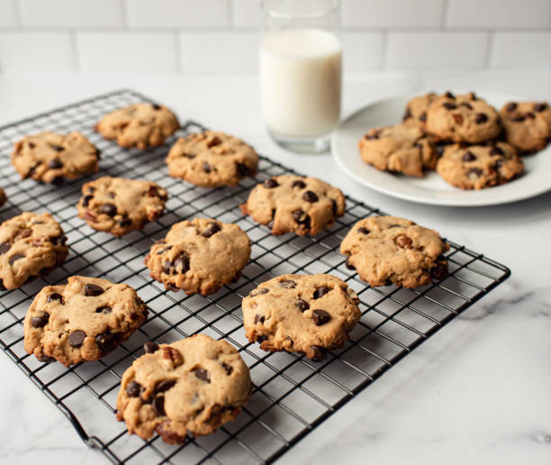 갓 구운 초콜릿 칩 쿠키와 우유를 흰색 대리석 카운터에 담습니다. - chocolate chip cookie cookie preparing food chocolate 뉴스 사진 이미지