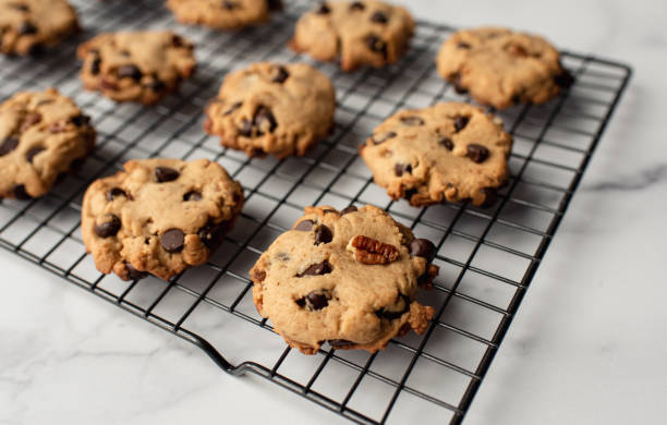 nahaufnahme von frisch gebackenen schokoladen-chip-cookies auf kühlregal. - plätzchen backen stock-fotos und bilder