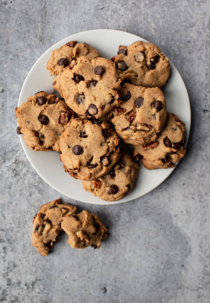 Close up of freshly baked chocolate chip cookies on plate from above. Close up of freshly baked chocolate chip cookies on plate from above. in Kingston, ON, Canada chocolate chip cookie top view stock pictures, royalty-free photos & images