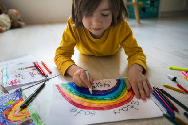 istock Happy boy drawing rainbow at home. Hope - concept. Covid-19 crisis 1219060985