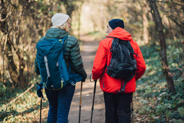 istock Man and woman carrying backpacks 1219063778