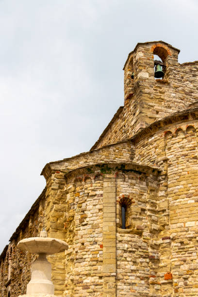 Pieve di Santa Maria Assunta or Parish Church of Santa Maria Assunta, the oldest religious building in San Leo, Province of Rimini, Region of Emilia-Romagna, Italy exterior partial view with a fountain