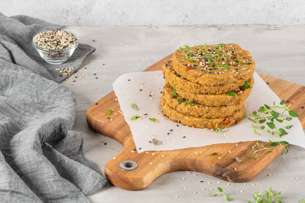 istock Raw veggie burger with lentils, vegetables and thyme leaves on kitchen countertop. 1219065312