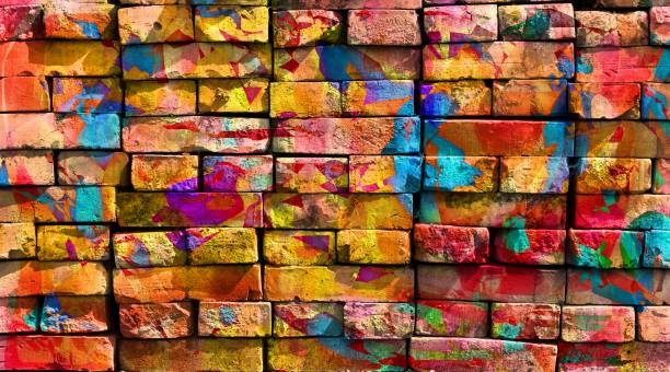 Creative graffiti artwork painted with green, orange, blue, purple and pink colors on wall of old brick building by skilled artist
