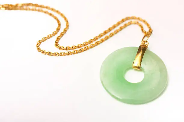 oriental jade pendant in a gold chain, popular among chinese tradition that wearing jade is a symbol of good luck